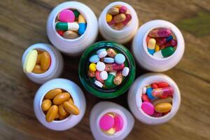 An Extensive and Colorful Assortment of Various Pills and Capsules Arranged in Bottles photo