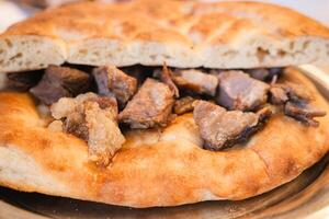 This is a Delicious Lamb and Flatbread Dish That is Served Beautifully on a Plate photo