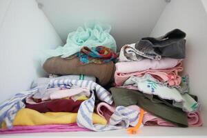 Wellorganized closet with neatly folded clothes and textiles for a tidy, minimalistic look photo