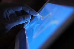 A detailed and closeup view of a hand engaging with a modern touchscreen electronic device photo