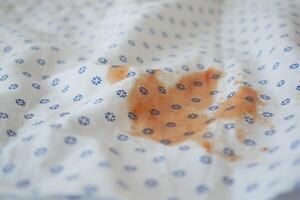 Stained Fabric CloseUp Detailed View of Patterned Material Featuring an Orange Mark photo
