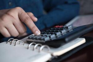A Person Engaged in Using a Calculator for Important Financial Calculations at Their Desk photo