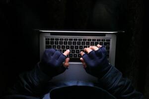 hacker hand stealing data from laptop top down photo