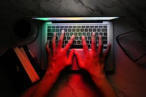 hacker hand stealing data from laptop top down photo