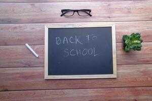 Essential Items for Going Back to School A Chalkboard, Stylish Glasses, and Greenery photo
