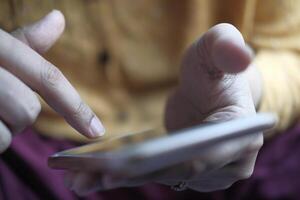 A closeup view of an individual using a smartphone, showcasing their focused gesture in detail photo
