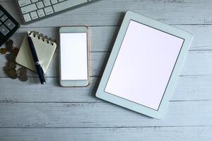 A Modern Workspace Featuring a Tablet and Smartphone Positioned on a Stylish Wooden Desk photo