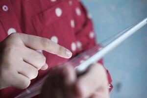 CloseUp View of Hands Actively Interacting with a Tablet Device, Engaging with Content photo