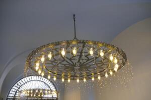 An Elegant and Modern Chandelier designed with a Stunning Golden Finish and Multiple Lights photo