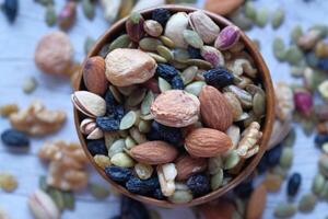 A colorful assortment of Nuts and Seeds beautifully arranged in a Wooden Bowl for all photo
