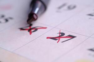 A bright red pen for marking dates on your calendar can improve organization and focus photo
