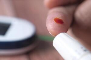 Blood Glucose Monitoring using a Glucometer along with a Blood Sample for Analysis photo