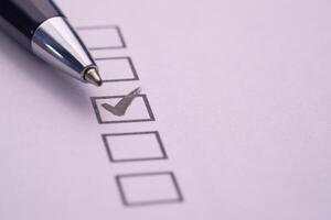 A comprehensive checklist featuring a checked box and a pen for enhancing productivity levels photo