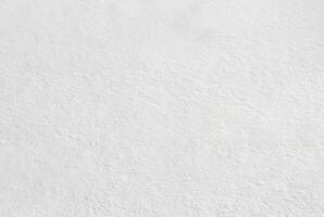 Closeup of fresh, untouched snow surface with natural soft textures, ideal for backgrounds or winter-themed designs. photo