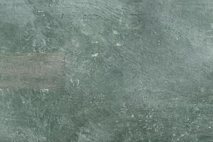 Close-up of rough green textured surface with visible scratches and brush marks, ideal for backgrounds. photo