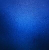 Abstract close-up of a blue textured background featuring a smooth gradient effect and subtle surface details. photo