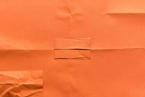 Minimal orange paper surface with visible folds and creases, ideal for backgrounds or design elements. photo