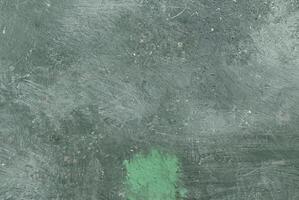 Close-up of rough green textured surface with visible scratches and brush marks, ideal for backgrounds. photo
