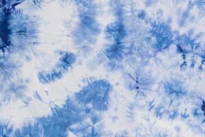 Blue and white tie-dye fabric texture with abstract patterns, perfect for backgrounds or textile designs. photo
