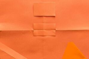 Minimal orange paper surface with visible folds and creases, ideal for backgrounds or design elements. photo