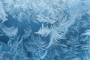 Detailed macro view of intricate frost patterns on a window surface during winter, forming natural ice crystals. photo