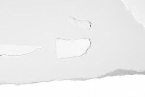 Close-up of a torn white paper edge against a clean, plain background, ideal for design or text space. photo