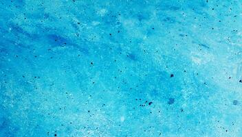 A close-up of an abstract blue textured surface with speckles and soft gradients, ideal for backgrounds or design use. photo