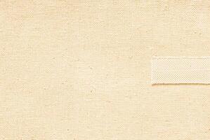 Beige fabric with visible woven texture, seamless material background, textile pattern close-up. photo