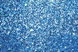Close-up of blue glitter texture with sparkling light reflections, perfect for festive backgrounds and decorative designs. photo