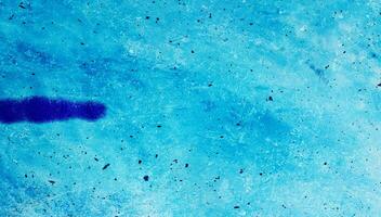 A close-up of an abstract blue textured surface with speckles and soft gradients, ideal for backgrounds or design use. photo