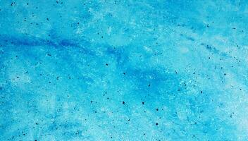 A close-up of an abstract blue textured surface with speckles and soft gradients, ideal for backgrounds or design use. photo