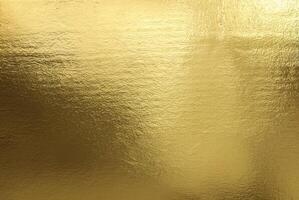 Shiny gold foil texture with a smooth, reflective surface ideal for backgrounds or luxurious designs. photo