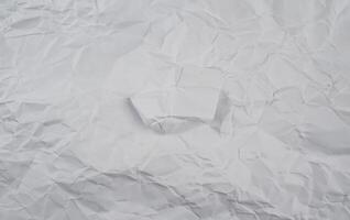 Crumpled white paper background with visible folds and creases, perfect for use in textures or design elements. photo