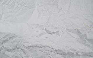 Crumpled white paper background with visible folds and creases, perfect for use in textures or design elements. photo