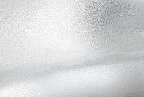 A close-up view of a frosted silver metallic texture with a subtle wave-like pattern, perfect for backgrounds or design elements. photo