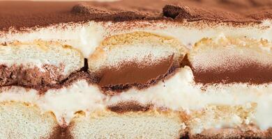 Macro shot of traditional Italian tiramisu dessert showing creamy layers of mascarpone, sponge cake, and cocoa. photo