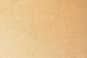 Beige textured wall surface close-up, ideal for use in backgrounds, interior design, and construction projects. photo