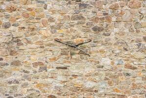 Close-up of a natural stone wall with rough texture and uneven stones, perfect for backgrounds. photo