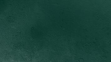 Dark green textured background with rough surface, suitable for design or text overlay. photo