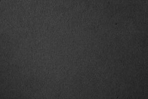 Close-up of dark textured black paper surface, ideal for backgrounds, textures, and minimalist design projects. photo