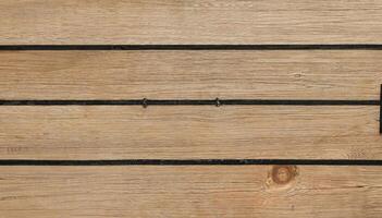 Close-up of wooden planks with dark grooves in a horizontal pattern, perfect for backgrounds, flooring, or architectural design. photo