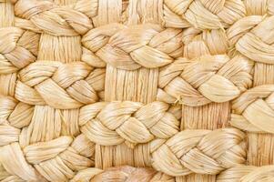 Macro shot of woven natural fibers, showcasing a detailed and textured pattern of braided straw or wicker material. photo