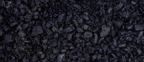 Detailed view of black coal texture with rugged, uneven surfaces, suitable for industrial or energy-related backgrounds. photo