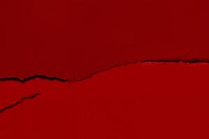 Close-up of a torn red paper texture with a rough edge, perfect for use as an abstract background or design element. photo