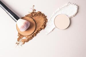 A sample of a round block of compact powder in a brown tone and a chic brush for applying makeup. loose powder sample. top view. layout for design photo