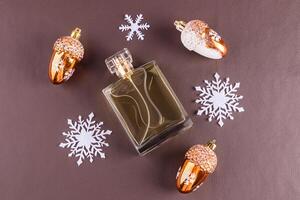 A chic bottle of expensive perfume on a leather brown background with white snowflakes. Blank mockup perfume bottle. template. top view. photo
