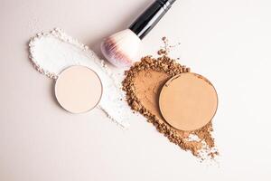A sample of a round block of compact powder in a brown tone and a chic brush for applying makeup. loose powder sample. top view. layout for design photo