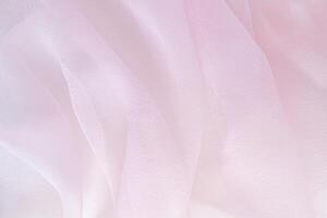 Elegant chiffon fabric with a pink color. The luxurious texture of the soft folds of the fabric. The concept of a festive background. design. photo