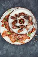 A plate of bacon wrapped dates. photo