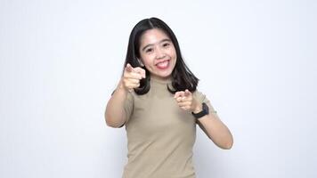 Beautiful Asian woman smiles and points directly at you, conveying a welcoming 'want you' gesture against a white background video